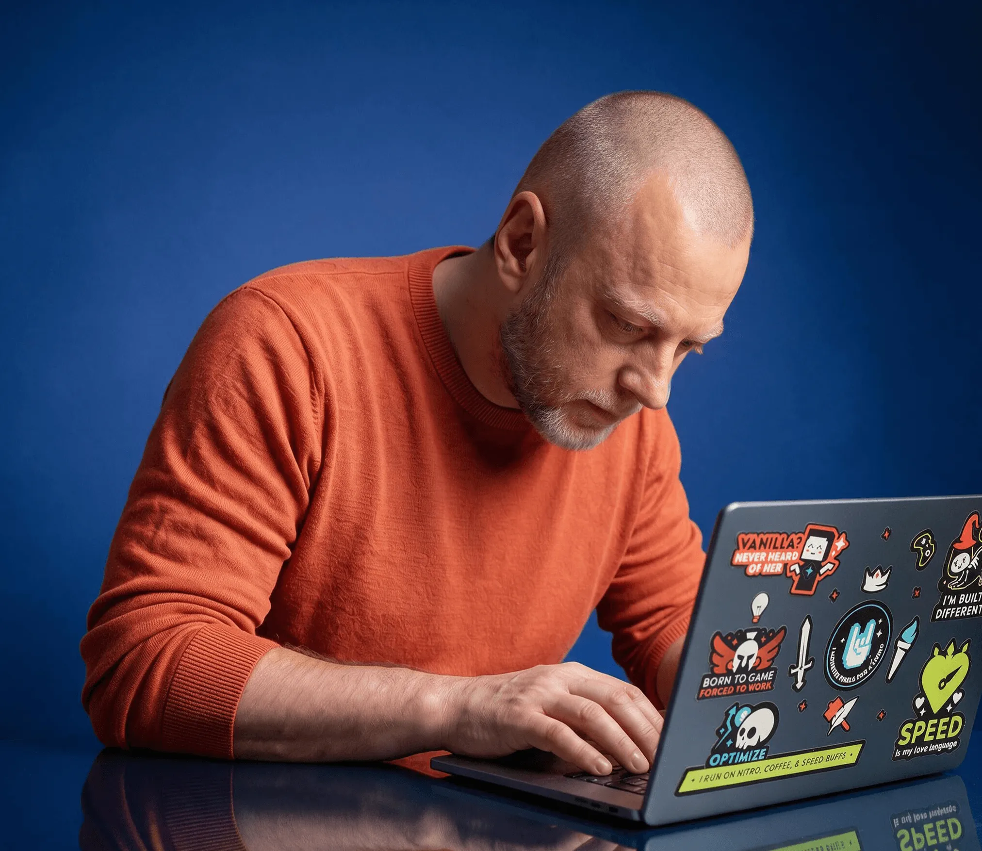 Me at a laptop covered in gaming stickers, against a blue ground.