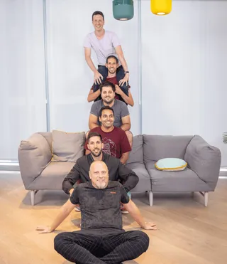 Six of the team stacked in a row on an office sofa, me on the floor at the front.